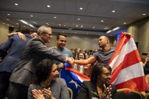 Dr. Whittaker shaking hands with student holding Puerto Rican flag